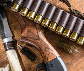 Pump action shotgun, 12 guage cartridge and hunting knife.