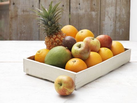 Crate of fruit on whitewashed wooden table