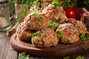 Stack of baked meatballs on a chopping board