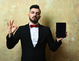 Advertiser with beard and confident face shows tablet and OK