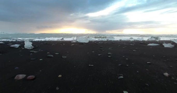 ICELAND – SEPTEMBER 2016 : Aerial shot over waves washing ashore on diamond beach at sunrise
