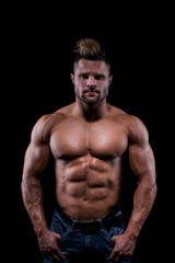 Fototapeta na wymiar Studio shot of body parts of a topless muscular sportsman over black background