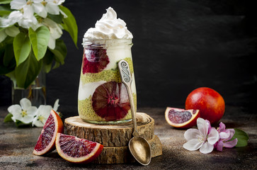 Detox layered matcha green tea chia seed pudding with blood oranges. Vegan dessert with coconut whipped cream. Healthy vegetarian breakfast, dieting, weight loss food. Copy space