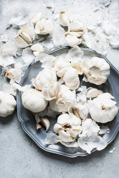 Overhead view of garlic bulbs and garlic cloves on serving dish