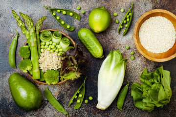 Vegan, detox green Buddha bowl recipe with quinoa, cucumber, broccoli, asparagus and sweet peas. Top view, flat lay