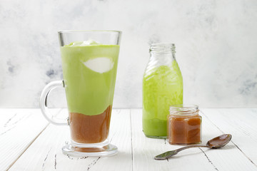 Matcha latte with salted caramel in tall glass.
