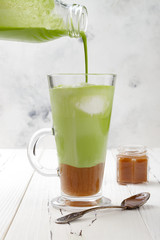 Matcha latte with salted caramel in tall glass.