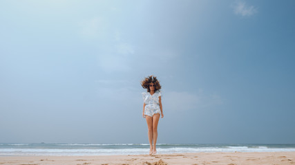 Fototapeta na wymiar Girl jumping on the beach with flying hair