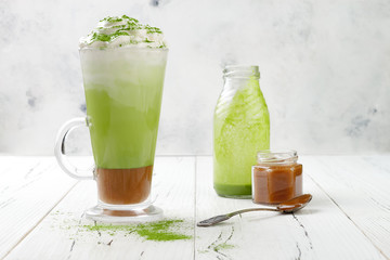 Matcha latte with salted caramel in tall glass. Copy space