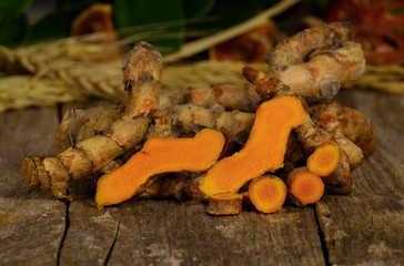 pile of fresh turmeric roots on wooden table
