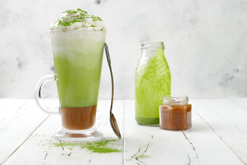 Matcha latte with salted caramel in tall glass. Copy space