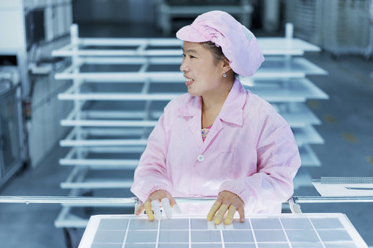 Female worker in solar panel assembly factory, Solar Valley, Dezhou, China