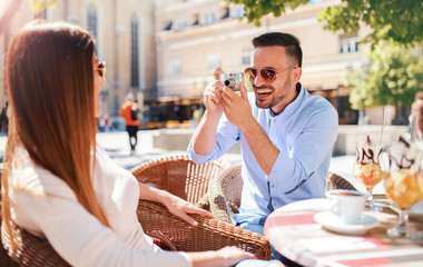Dating in the cafe. Loving couple having fun with camera in the cafe. Dating, love, relationships