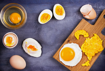 Different ways of cooking eggs: scrambled, omelette, boiled, raw and poached. Flat lay, top view with copy space