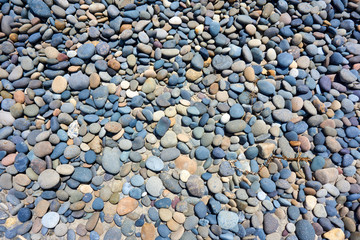 Round pebbles with sand near the sea