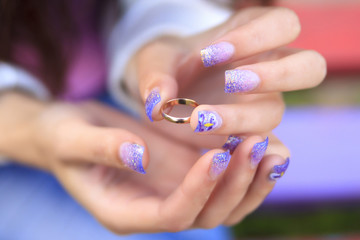 Detail of one hand with gold ring. Manicure of the girl.