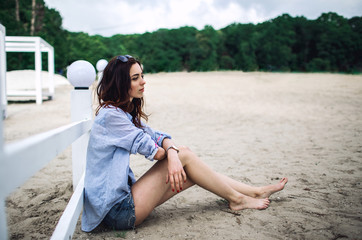 Portrait of young brunette woman sitting on the beach