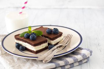 Chocolate biscuit with milk filling and berries on a plate. Chocolate-milk kids dessert. - 159610711