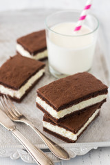 Chocolate biscuit with milk filling on a plate. Chocolate-milk kids dessert. - 159610733