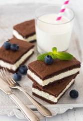 Chocolate biscuit with milk filling and berries on a plate. Chocolate-milk kids dessert. - 159610734