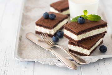 Chocolate biscuit with milk filling and berries on a plate. Chocolate-milk kids dessert. - 159610755