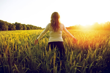 Happy young woman in white dress on cereal field