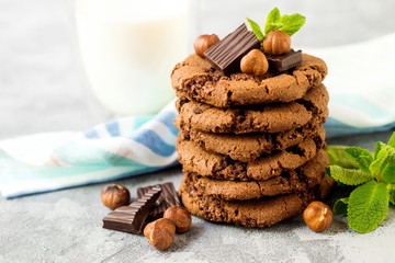 Chocolate cookies for breakfast with mint and hazelnut and a glass of milk on a gray table - 159611166