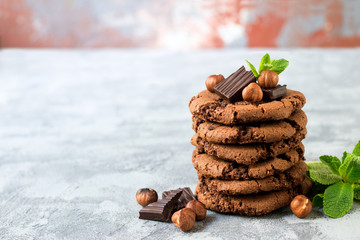 Chocolate cookies for breakfast with mint and hazelnut and a glass of milk on a gray table - 159611174