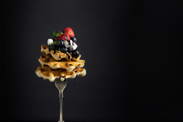 A stack of Belgian waffles with berries.(Strawberry, blueberry), marshmelow, and chocolate sauce on a fork, with levitation - 159611312