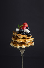 A stack of Belgian waffles with berries.(Strawberry, blueberry), marshmelow, and chocolate sauce on a fork, with levitation - 159611328