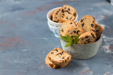Italian cantuccini in a ceramic bowl on a table, with a red checkered napkin - 159611500