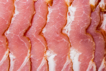 Close-up, background of raw bacon, a popular meat product, ingredient of many dishes.