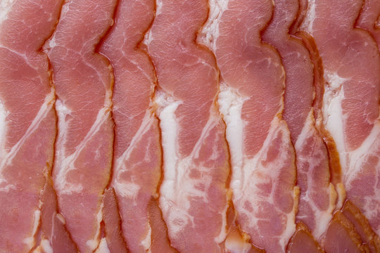 Close-up, background of raw bacon, a popular meat product, ingredient of many dishes.
