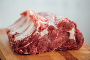 piece of raw beef meat on wooden board