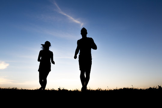 silhouette of a jogger couple in sunrise