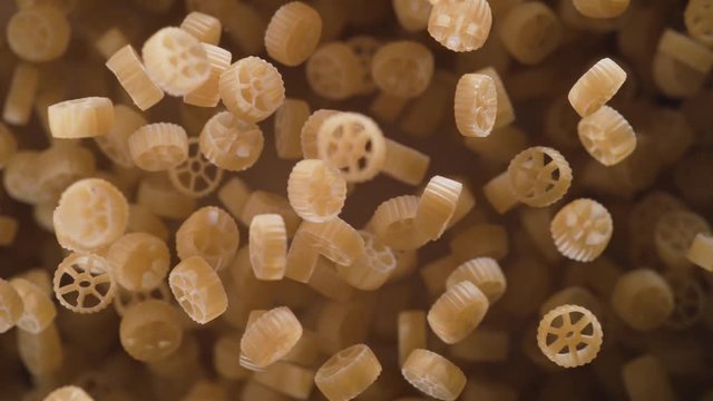 Raw wagon wheels pasta flies after being exploded. Shot with high speed camera, phantom flex 4K. Slow Motion.
