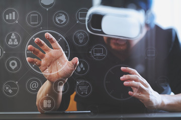 businessman wearing virtual reality goggles in modern office with mobile phone using with VR headset with screen icon diagram