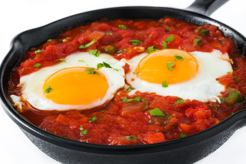 Mexican breakfast: Huevos rancheros in iron frying pan isolated on white background
