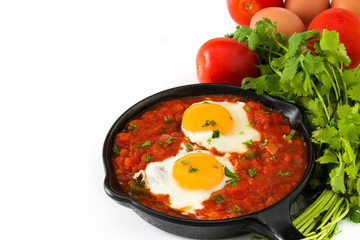 Mexican breakfast: Huevos rancheros in iron frying pan isolated on white background
