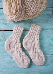 knitted socks and yarn on wooden surface