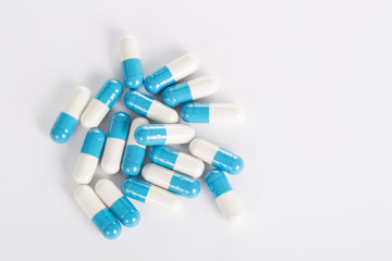 Top view of medical blue pills on the white background.