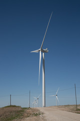 Fototapeta premium Windmill in front of a perfect blue sky with other windmills behind it
