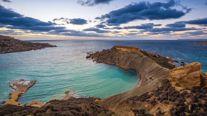 Mgarr, Malta - Panorama of Gnejna bay, the most beautiful beach in Malta at sunset with beautiful...