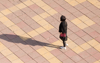 The girl is walking along paving stones