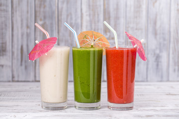 Fresh avocado, strawberry and banana drinks on wooden table, assorted protein cocktails with fresh fruits.
