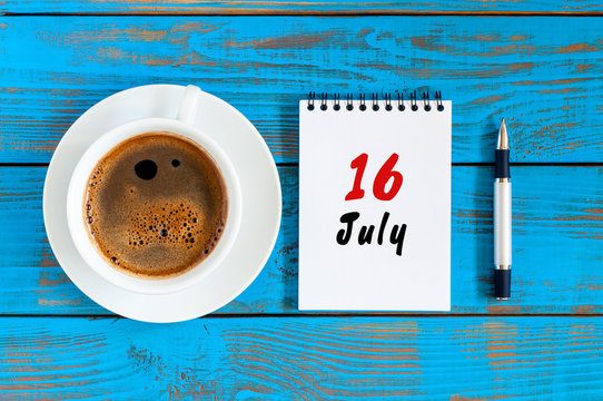 July 16th. Day 16 of month, calendar on blue wooden table background with morning coffee cup. Summer concept