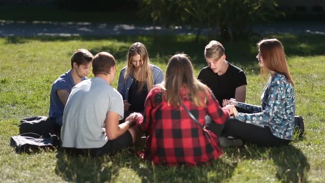 Young christians sitting in circle and praying