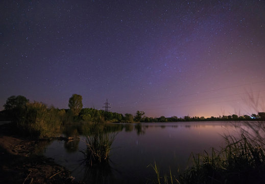 view on starry night sky above lake
