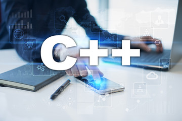 Businessman working in office, pressing button on virtual screen and selecting c++.