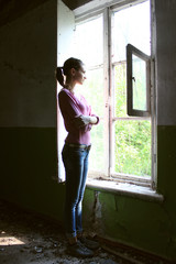 Woman looking through the old window